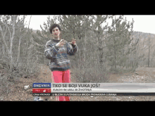 a woman in a sweater and pink pants is standing in the woods with dnevnik written on the bottom of the screen