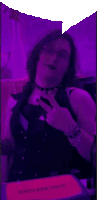 a woman taking a picture of herself in front of a purple light