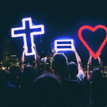 a group of people are holding up a cross and a heart