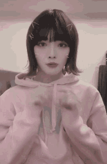 a girl wearing a pink hoodie with a cat face on her forehead