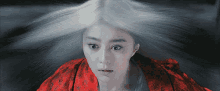 a woman with white hair is wearing a red robe