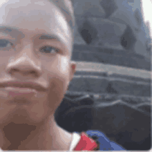 a young man is taking a picture of himself in front of a large tire .