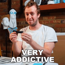 a man in a white shirt is holding a very addictive object