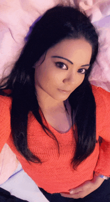 a woman in a red sweater is laying down on a bed