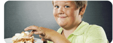 a boy in a green shirt is holding a piece of cake