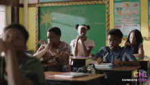 a group of children sit at desks in a classroom with a sign that says the chi sundays at the bottom