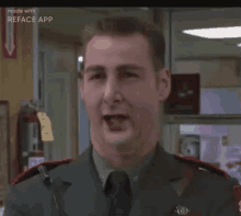 a man in a military uniform is making a funny face while standing in a room .