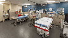 an empty operating room with two stretchers and a monitor