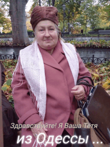 a woman in a pink coat is standing in a park holding a black briefcase