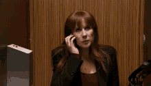 a woman is talking on a cell phone in an elevator