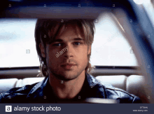 a man sitting in the back seat of a car with alamy written on the bottom