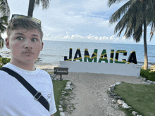 a man in front of a sign that says jamaica