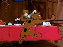 scooby doo and shaggy are dancing on a table with food