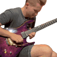 a man is playing a purple electric guitar with a ring on his finger