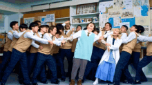 a group of people are posing for a picture in a room with a bulletin board that says ' a ' on it