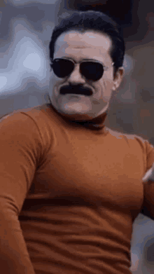 a man with a fake mustache and sunglasses is wearing a turtleneck sweater and sunglasses .