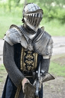 a man in a knight 's armor is holding a sword and a helmet .