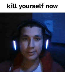 a man wearing headphones is looking at the camera with the words `` kill yourself now '' written above him .