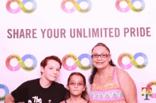 a woman and two children pose for a photo in front of a sign that says share your unlimited pride