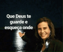 a woman is smiling in front of a full moon with the words que deus te guarde e esqueça onde written above her .