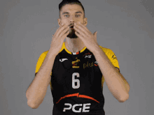 a man in a black and yellow pge jersey