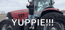 a man giving a thumbs up next to a red case tractor