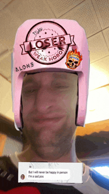 a man wearing a pink helmet that says loser weak moron on it