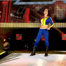 a woman is standing on a stage wearing a blue and yellow outfit .