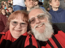 a man with glasses and a beard smiles for a picture with a woman