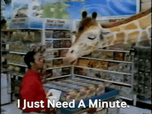 a giraffe licking a man 's face in a store with the words i just need a minute below it