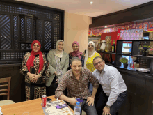 a group of people are posing for a picture in a restaurant