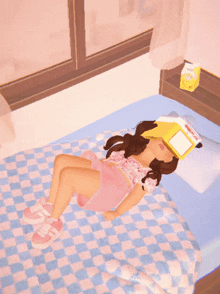 a girl laying on a bed with a book on her head and a carton of milk