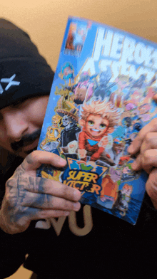 a man in a black hat holds up a comic book titled heroes a star