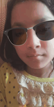 a girl wearing sunglasses and a yellow shirt