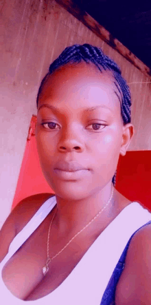 a woman wearing a braided hairstyle and a white tank top