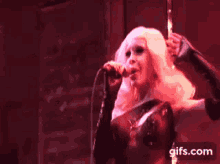 a pixelated image of a woman singing into a microphone with the website gifs.com in the lower right corner