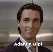 a man in a suit and tie is smiling with the name adamin dipi below him