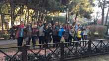 a group of people standing in front of a wooden fence with their arms in the air