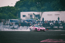 a pink car is drifting on a track with a sign that says hsr