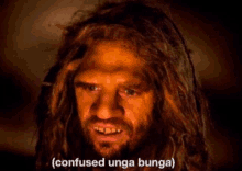 a man with long hair and a beard is looking at the camera with the words confused unga bunga below him .