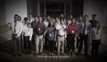 a group of people standing in front of a building with the words hum sab ke laude lag gaya written on the bottom