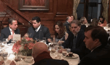 a group of people are sitting at a table with a place card that says reserved