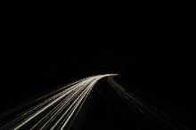 a long exposure photo of a highway at night with a few lines of light