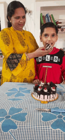 a boy wearing a shirt that says endless is eating cake