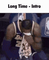 a basketball player is sitting in the stands with his head in his hands and the caption long time intro