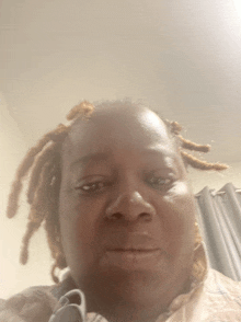 a woman with dreadlocks looks at the camera with her eyes closed