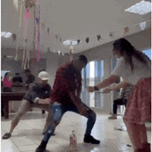 a group of people are dancing in a room with a bottle of alcohol on the floor .