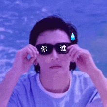 a man wearing sunglasses has chinese writing on his face