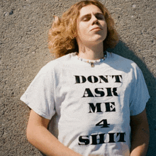 a man wearing a white shirt that says " don 't ask me 4 shit "