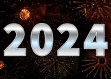 the year 2024 is written in silver on a black background with fireworks in the background .